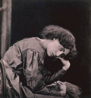 Jane Morris seted, elbow on her leg and head propped on her hand